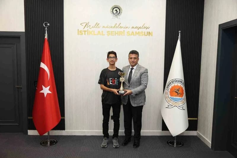 Başkan Halit Doğan ve Türkiye Dron Şampiyonu Kerem Yiğit şampiyonluk kupasıyla hatıra fotoğrafı çektiriyor