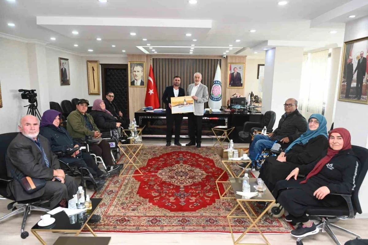 Isparta Yürüme Engelliler Yaşam Derneği Başkanı Erşan Kaplan ve beraberindeki dernek üyeleri, Isparta Belediye Başkanı Ş