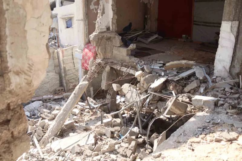 Gazze'de yıkılma riski taşıyan hasarlı bir binada kış şartlarında yaşayan Filistinli aileler