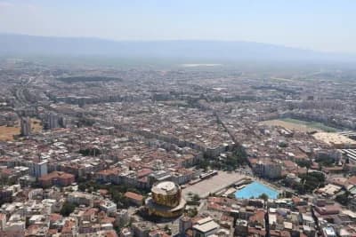 Aydın’da ikamet izinli yabancı sayısının arttığını gösteren grafik ve şehir görüntüsü