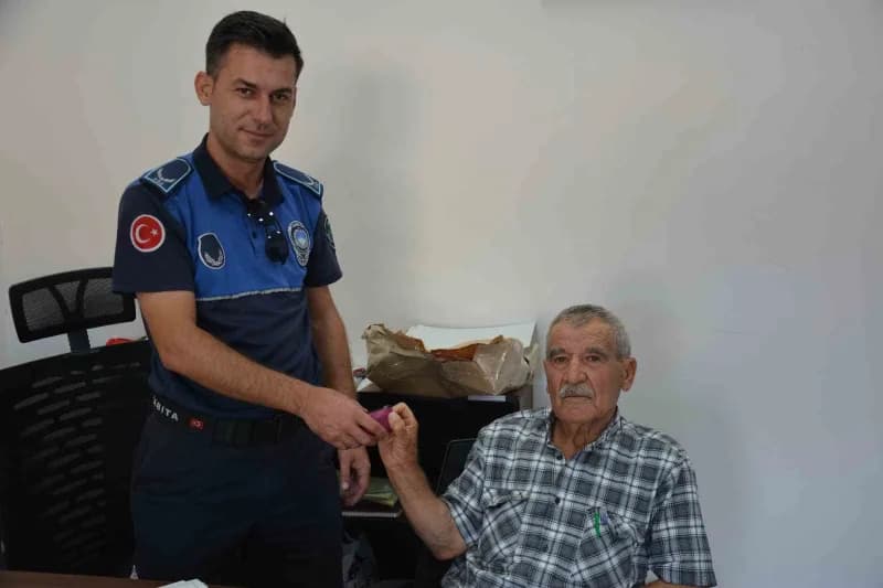 Manisa Demirci'de Kıbrıs Gazisi Ahmet Ünalan, bulduğu altınları zabıta ekiplerine teslim ederken