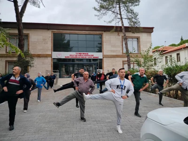 Kula İlçe Sağlık Müdürlüğü bahçesinde düzenlenen sağlıklı yaşam etkinliğinde vatandaşlar fiziksel aktivite yapıyor