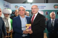 Malatya Kitap Fuarı'nda yazarlar ve ziyaretçiler kitap stantları arasında sohbet ediyor