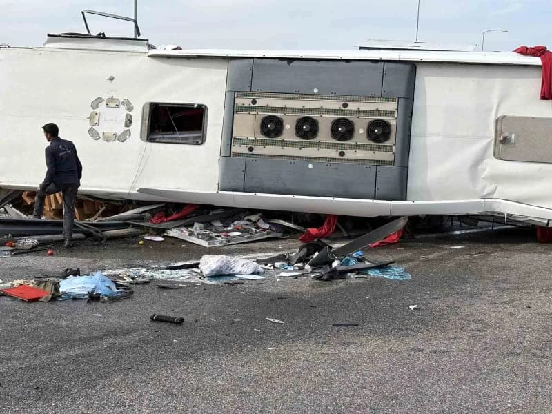 Devrilen yolcu otobüsü ve yoldan çıkan tır çekiciler yardımıyla olay yerinden kaldırılıyor.