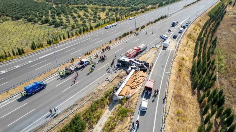 Devrilen yolcu otobüsü ve yoldan çıkan tır çekiciler yardımıyla olay yerinden kaldırılıyor.