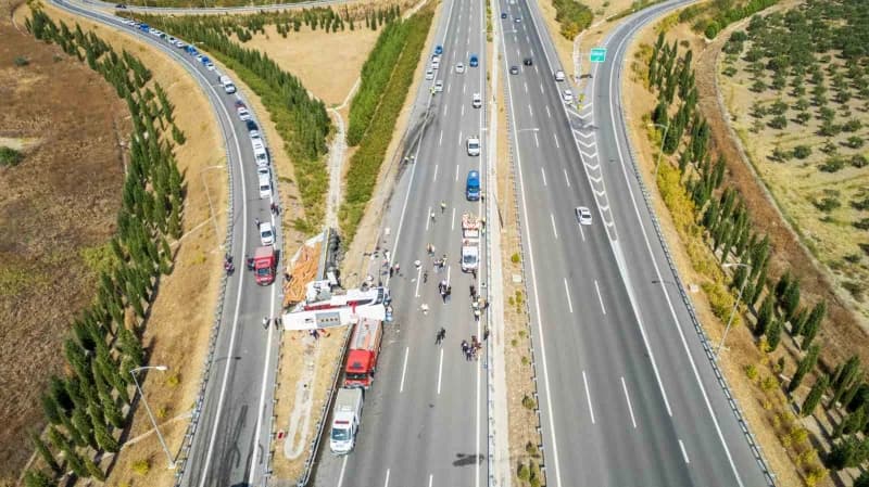Devrilen yolcu otobüsü ve yoldan çıkan tır çekiciler yardımıyla olay yerinden kaldırılıyor.
