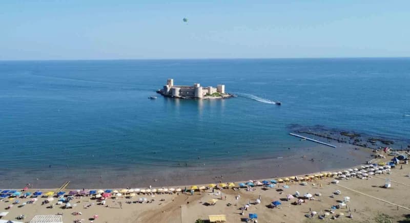 Mersin Kızkalesi sahilinde sonbaharda denize giren tatilciler ve sakin sahil görüntüsü