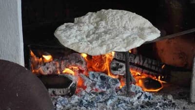 Manisa Karaoğlanlı Mahallesi’nde kadınlar odun ateşi başında Ramazan yufkası açıyor