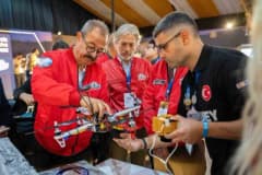 SANKO Holding Yönetim Kurulu Başkanı Adil Sani Konukoğlu, TEKNOFEST 2026'da gençlerle projelerini dinlerken
