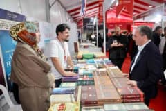 Sultanbeyli Kitap Fuarı'nda ziyaretçiler yayınevi stantlarını geziyor ve kitapları inceliyor