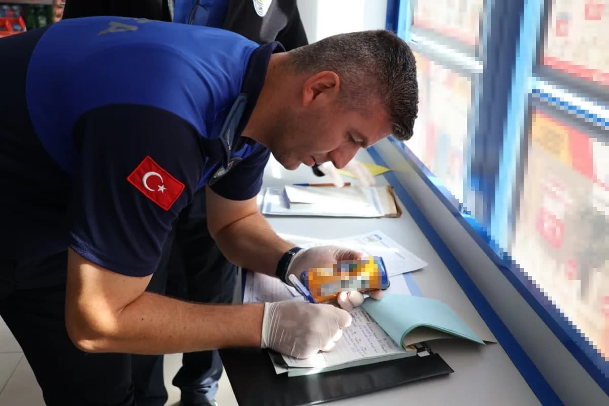 Babaeski’de zabıta ekipleri marketlerde son kullanma tarihi denetimi yaparken ürünleri inceliyor