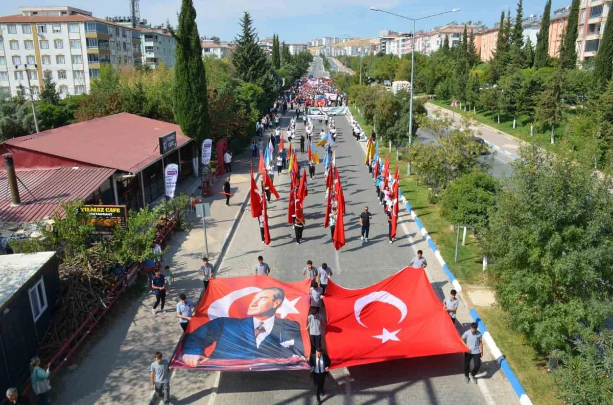 Adıyaman Besni'de 28. Eğitim Bayramı yürüyüşü ve açılış töreninden katılımcılar Türk bayraklarıyla yürürken