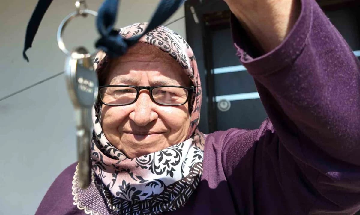 Mersin Erdemli'de gönüllülerin desteğiyle yapılan yeni evinde mutlu olan 69 yaşındaki Fatma Dinç anahtarını gösteriyor
