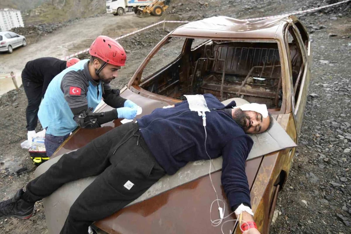 Gümüşhane’de UMKE ekipleri yağış altında heyelan sonrası trafik kazası tatbikatı yaparken yaralıları tahliye ediyor