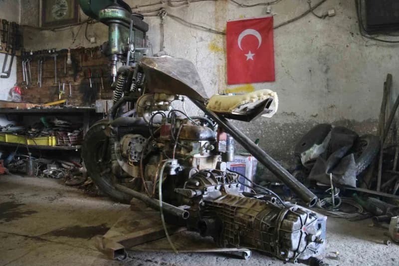 Sivas'ta genç Ahmet Yılmaz, otomobil motorundan yaptığı motosikletin iskeletini atölyede inceliyor