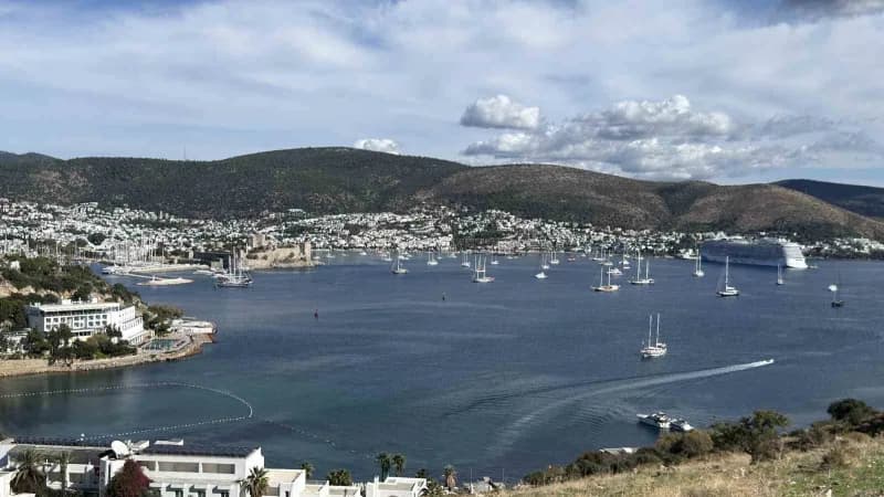 Bodrum sahilinde sağanak sonrası güneşli havada denize giren turistler