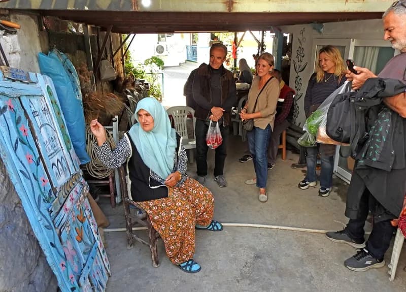Çeşme Germiyan Mahallesi’nde eski bir kapı, Nuran Erden’in hayat ağacı ve servi motifleriyle renklendirilmiş sanat eseri