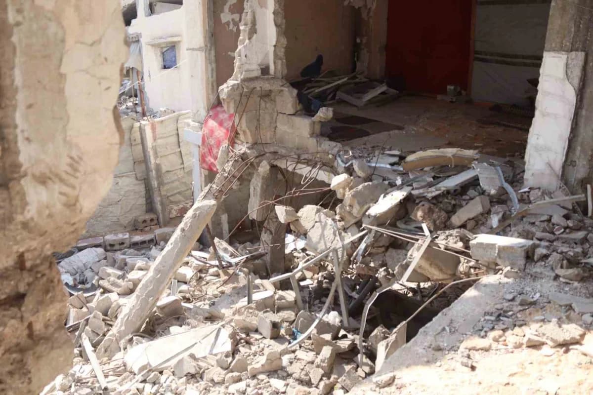 Gazze'de yıkılma riski taşıyan hasarlı bir binada kış şartlarında yaşayan Filistinli aileler
