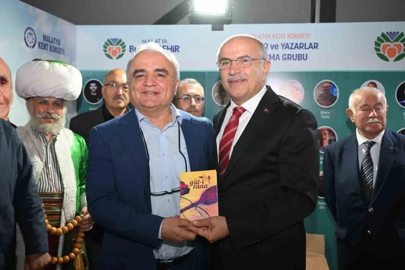 Malatya Kitap Fuarı'nda yazarlar ve ziyaretçiler kitap stantları arasında sohbet ediyor